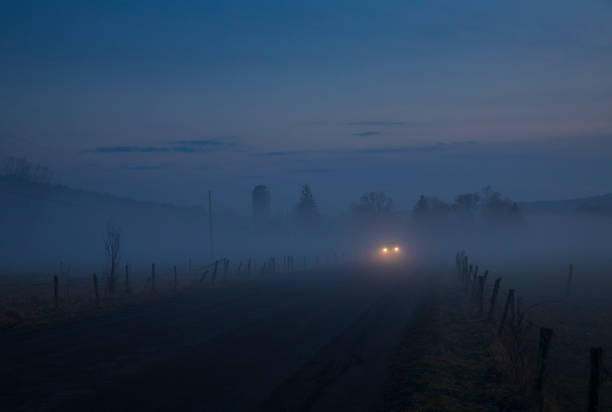 A warm winter's fog haunts the landscape of Jenksville, a small rural town in New York State, consisting of farms, open air, two-lane country roads and headlights in the distant..